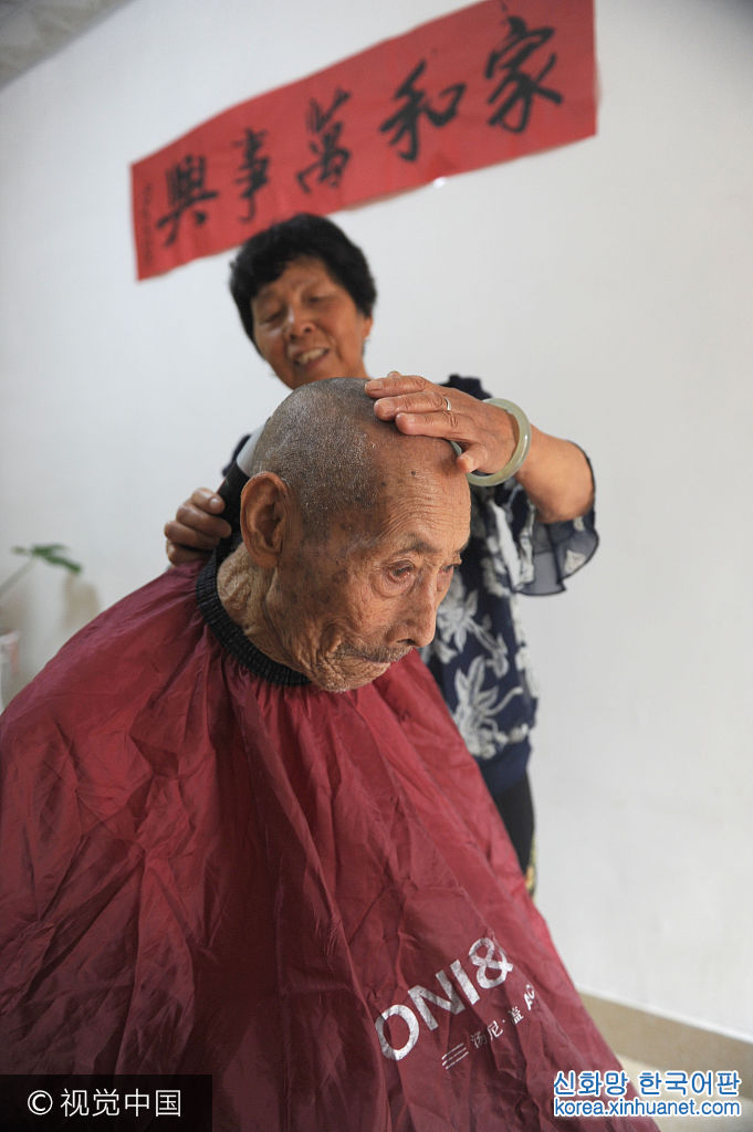 ***_***2017年7月9日，安徽淮南市农科所家属区内，78岁的儿媳廖静华为103岁的公公赵家明理发。
