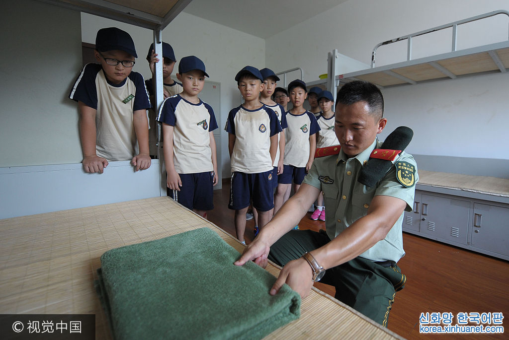 ***_***2017年7月25日，浙江舟山，教官指导参加军事夏令营的小朋友把毛毯叠成“豆腐块”。