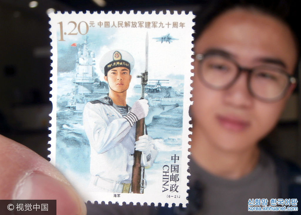 ***_***2017年8月1日，一名集邮爱好者在江苏苏州邮政局展示《中国人民解放军建军90周年》纪念邮票。