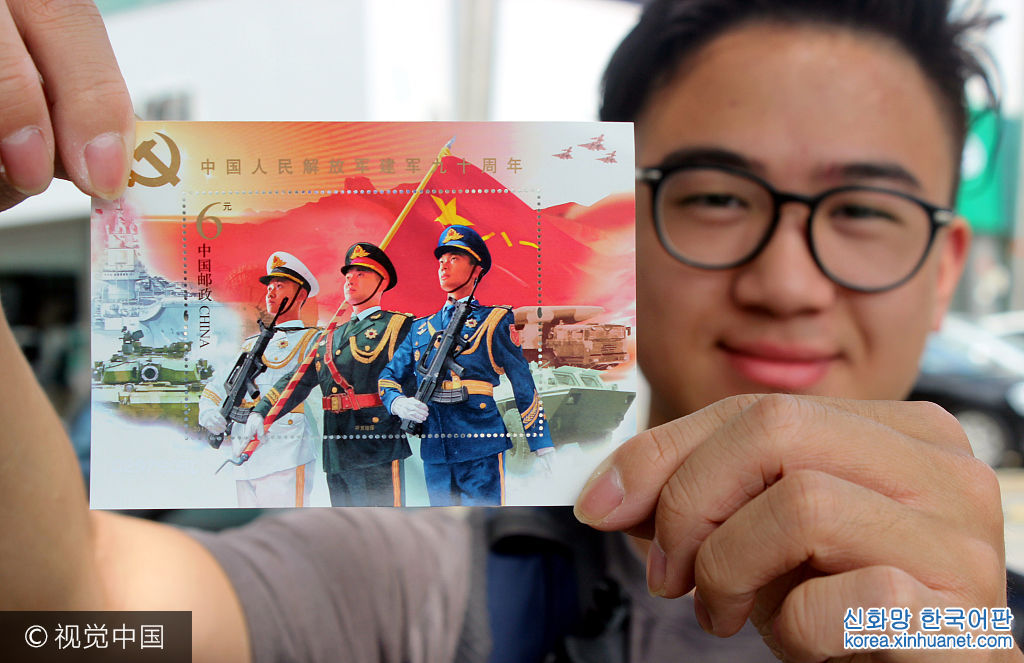 ***_***2017年8月1日，一名集邮爱好者在江苏苏州邮政局展示《中国人民解放军建军90周年》纪念邮票小型张“听党指挥”。