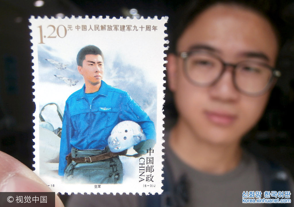 ***_***2017年8月1日，一名集邮爱好者在江苏苏州邮政局展示《中国人民解放军建军90周年》纪念邮票。