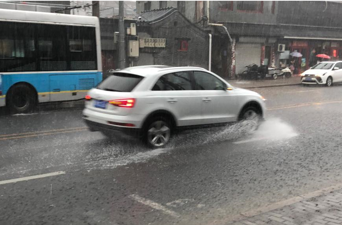 베이징 시내 폭우가 지속되고 행인과 차량 비를 뚫고 지나